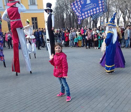 Девочка с аниматорами на ходулях 